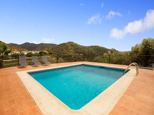 una piscina con sedie e montagne sullo sfondo di Belvilla by OYO La Loma a Los Vados