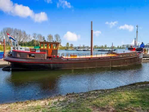 un barco está atracado en el agua en un río en Luxury boat in Kerkdriel, en Kerkdriel