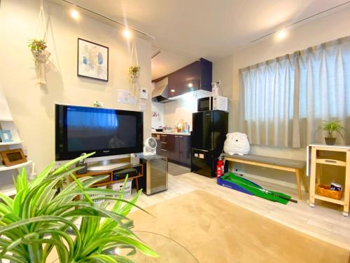 uma sala de estar com uma grande televisão de ecrã plano em Hachi Kamakura KOIWA em Tóquio