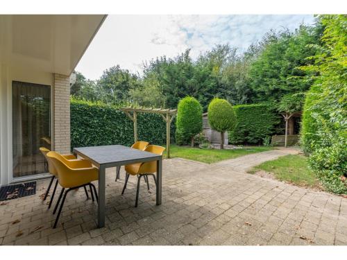 una mesa y sillas en un patio en Bungalow close to seaside resort De Koog en Westermient