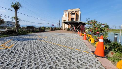 a cobblestone street with orange cones in front of a building at ChaoPingJia Homestay in Luodong