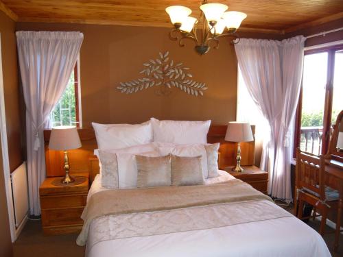 a bedroom with a large bed with white pillows at Berghaven in Underberg