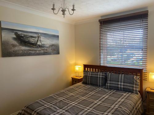 a bedroom with a bed and a picture of a boat at Waterfront House In The Heart Of St Neots in Saint Neots