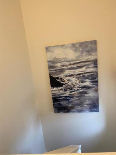 a painting of the ocean on a wall at Waterfront House In The Heart Of St Neots in Saint Neots