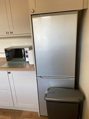 a refrigerator in a kitchen with a microwave at Waterfront House In The Heart Of St Neots in Saint Neots