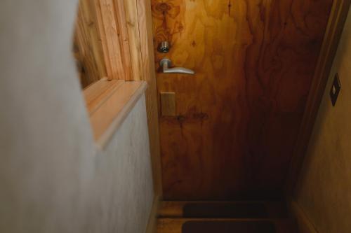 a bathroom with a wooden door and a staircase at guesthouse SHIBAFU in Kamakura