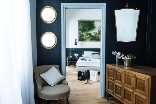 una camera con letto, sedia e specchio di Soprarno Suites a Firenze