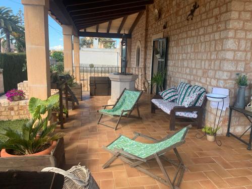 a patio with chairs and a couch and a table at Ca Na Marina in Cala Llombards