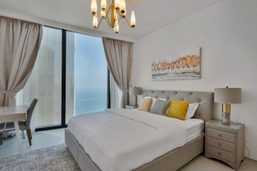 a bedroom with a large bed and a chandelier at Daniels 3BR with M Address JBR Dubai Eye View in Dubai