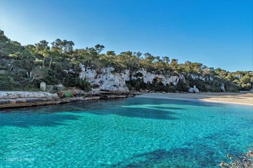 a river with turquoise water and a beach at Ca Na Marina in Cala Llombards