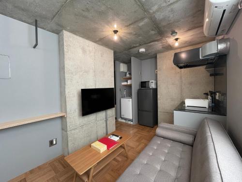 a small living room with a couch and a table at PRISM INN OGU in Tokyo