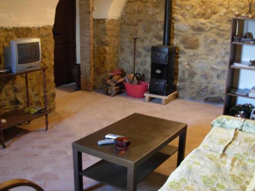a living room with a wood stove and a table at Holiday Home in Tuscany with Natural Pond in Gavedo