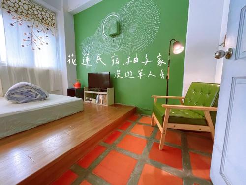 a bedroom with a bed and a green wall at Yuzi Homestay in Hualien City