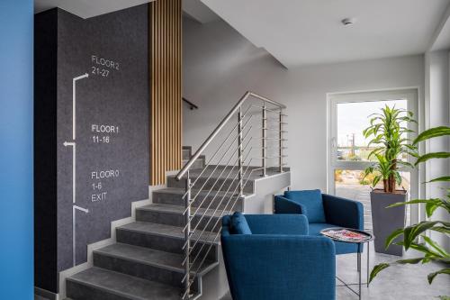 a staircase with a blue chair and a blue couch at Autohof 171 Hotel Hegyeshalom in Hegyeshalom