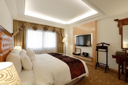 a hotel room with a bed and a television at Hotel Sunshine in Kaohsiung