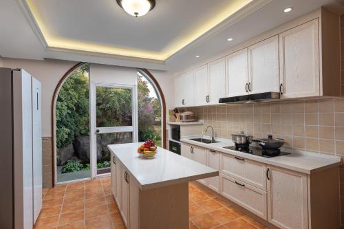 a kitchen with white cabinets and a large window at Xiamen C&D Hotel-Free Welcome Snacks-Oasis Garden in Xiamen