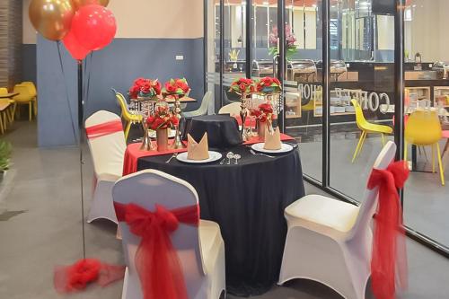 a table with chairs and a table with hats on it at Hotel Mutiara Padang Sidimpuan Mitra RedDoorz in Padangsidimpuan