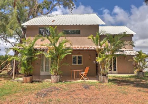 a house with palm trees in front of it at Coco room in Blue Bay