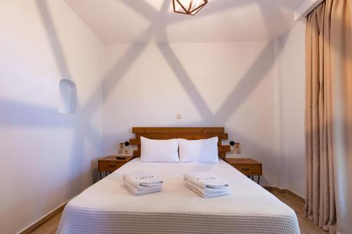 a bedroom with a bed with two towels on it at Casa Luxury Suites in Paliouri