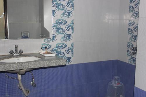 a bathroom with a sink and a mirror at The Blue Lagoon Hotel Premium in Cuttack