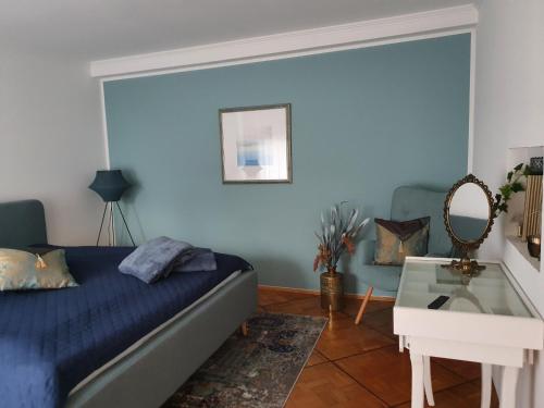 a bedroom with a bed and a table and a mirror at 2 Zimmer Domizil am Südhang mit Terrasse und Pool in Ortenberg