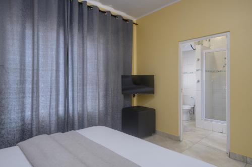 a bedroom with a bed and a television and a bathroom at Ushaka Holiday Apartments in Durban