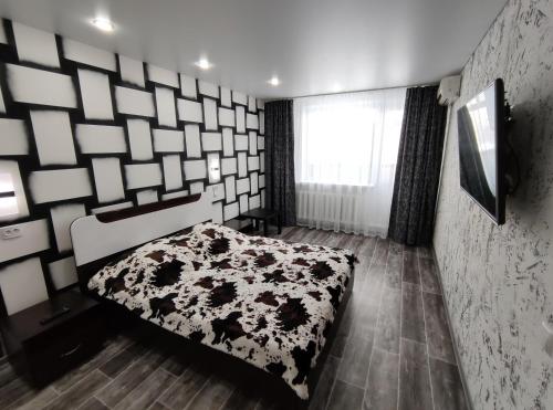 TuymazyにあるSutki 700 Komarova 28のベッドルーム1室(ベッド1台、白黒の毛布付)