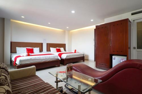 a hotel room with two beds and a couch at ABC HOTEL BÌNH TÂN in Ho Chi Minh City