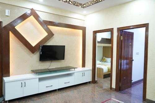 a living room with a flat screen tv on a wall at Classia Suites in Bengaluru
