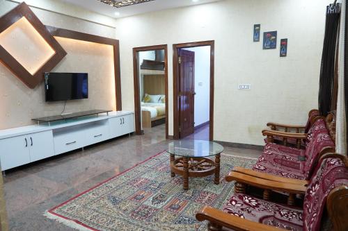 a living room with a couch and a tv at Classia Suites in Bengaluru