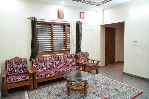 a living room with two couches and a glass table at Classia Suites in Bengaluru