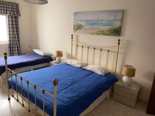 a bedroom with two beds and a painting on the wall at Side Seaview St Pauls Bay Apartment in St. Paul's Bay