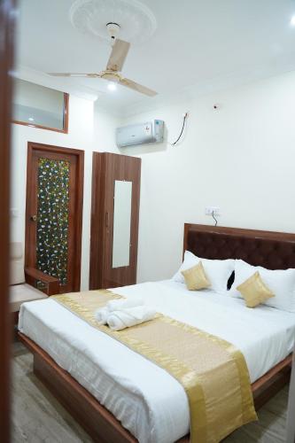 a bedroom with a bed with white sheets and a window at Classia Suites in Bengaluru
