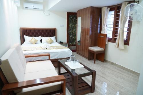 a bedroom with a bed and a couch and a table at Classia Suites in Bangalore