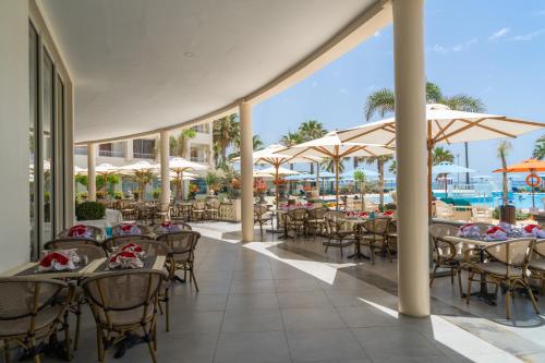 an outdoor dining area with tables and umbrellas at Khayam Garden Beach Resort & Spa in Nabeul