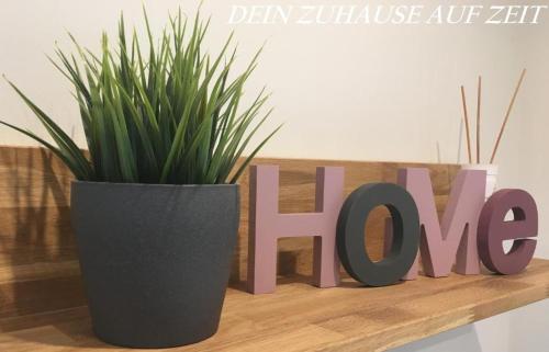 a sign that says love next to a potted plant at Ferienwohnungen Heideidylle in Amelinghausen