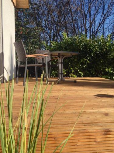 a patio with a table and chairs on a wooden deck at Ferienwohnungen Heideidylle in Amelinghausen