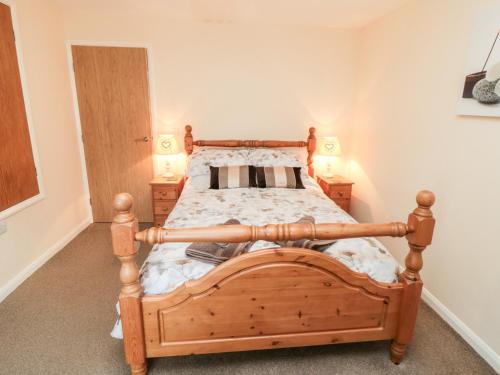 Un dormitorio con una cama de madera y dos mesitas de noche. en Gough Bank, en Bridlington