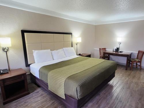 a hotel room with a large bed and two tables at Flex Studios in San Antonio