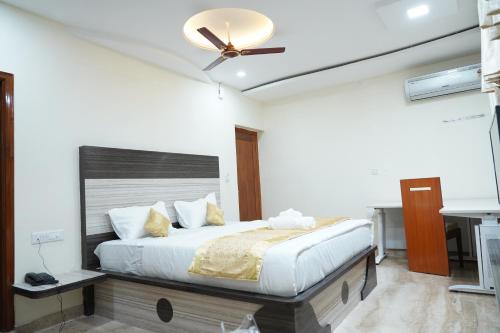 a bedroom with a bed with a ceiling fan at Classia Suites in Bengaluru