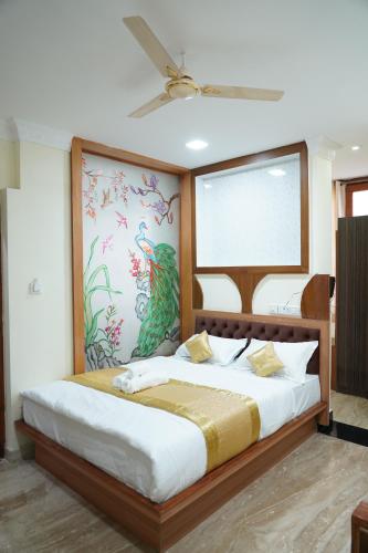 a bedroom with a large bed with a painting on the wall at Classia Suites in Bengaluru