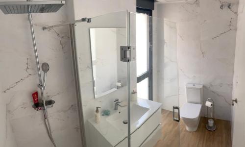 La salle de bains blanche est pourvue d'une douche et de toilettes. dans l'établissement TERRAZAS DEL MAR with POOL, à Torremolinos