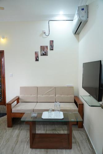 a living room with a couch and a tv at Classia Suites in Bengaluru