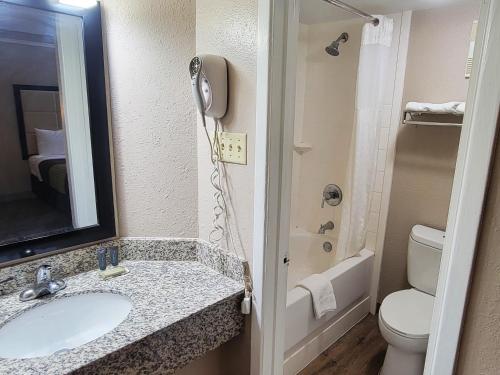 a bathroom with a sink and a toilet and a phone at Flex Studios in San Antonio