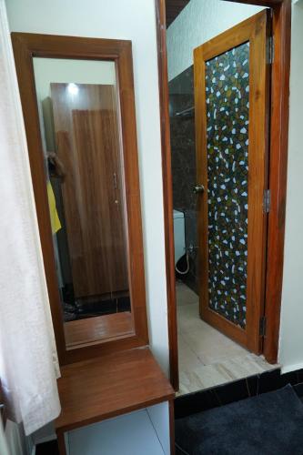 a bathroom with a glass door with a mirror at Classia Suites in Bengaluru