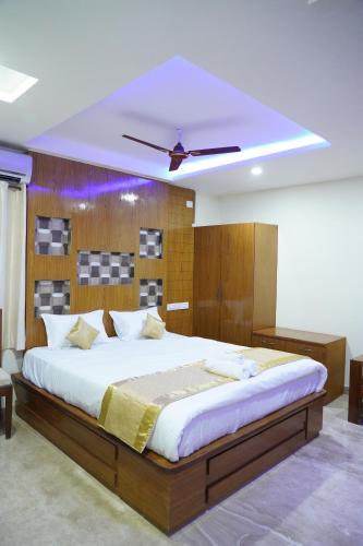 a bedroom with a large bed with a ceiling at Classia Suites in Bengaluru