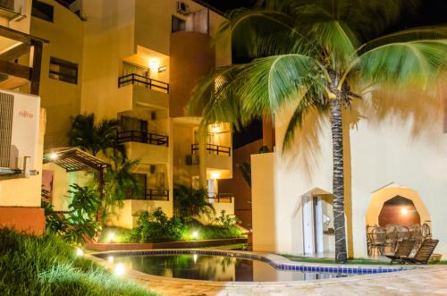 a hotel with a palm tree in front of a building at Hotel Palmanova in Maceió