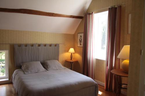a bedroom with a bed and a window at Les Jardins de L'Aulnaie - FERME DEFINITIVEMENT in Fontaine-sous-Jouy