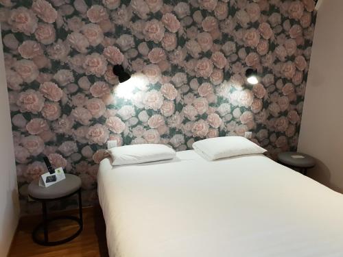 a bedroom with a bed with a floral wall at Logis Aux Maisons in Maisons-lès-Chaource