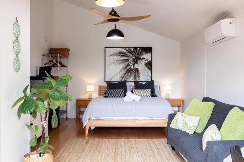um quarto com uma cama e um sofá em Tallows Studio -Modern, tranquil, dog friendly,2 mins to the beach em Suffolk Park